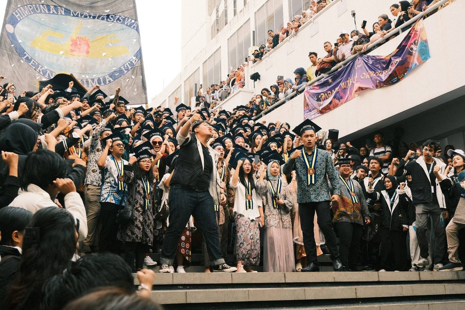 Members celebrating and tossing caps